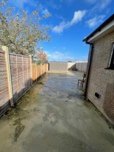 an empty parking lot with a fence and a bench at One Bedroom Annex with Private Entrance in Morden