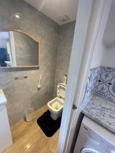 a small bathroom with a toilet and a sink at One Bedroom Annex with Private Entrance in Morden