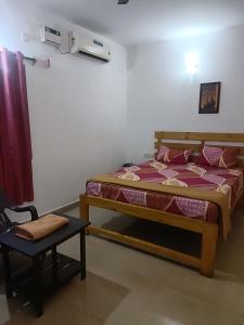 a bedroom with a bed and a chair in a room at Hotel Khushi Waves in Arpora