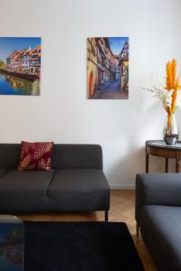 a living room with a couch and paintings on the wall at La Maison de maître - centre historique - 3 rue henriette in Mulhouse