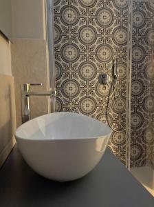 una vasca da bagno bianca seduta su un bancone in bagno di HappynessHouse_Locazione turistica a Trani