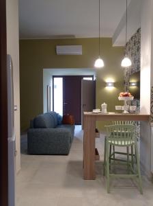 una cucina e un soggiorno con tavolo e divano di HappynessHouse_Locazione turistica a Trani