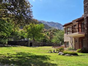 a house with a yard with a mountain in the background at COSTA COM Departamentos de Montaña in Merlo