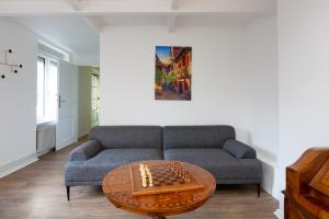 a living room with a couch and chessboard on a table at La Maison de maître - centre historique - 3 rue henriette in Mulhouse +90 photos