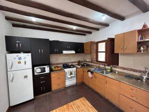 a kitchen with a white refrigerator and wooden cabinets at Casa Campestre en Ibarra in Ibarra