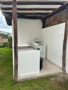 a white refrigerator sitting inside of a garage at Casa Campestre en Ibarra in Ibarra