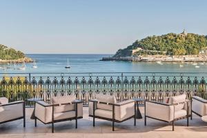 a group of chairs and tables in front of a fence at Nobu Hotel San Sebastián in Donostia-San Sebastián