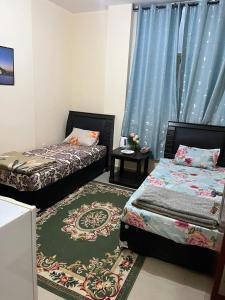 1 Schlafzimmer mit 2 Betten und einem Teppich in der Unterkunft Fabulous Luxury Room in Abu Dhabi