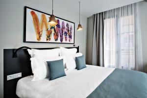 - une chambre dotée d'un grand lit avec des oreillers bleus et blancs dans l'établissement Villa du Taur, à Toulouse