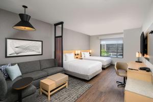 a hotel room with a couch and a bed at Hyatt Place Albany Downtown in Albany +26 photos