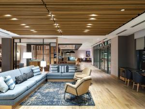 a living room with a blue couch and chairs at Hyatt Place Albany Downtown in Albany