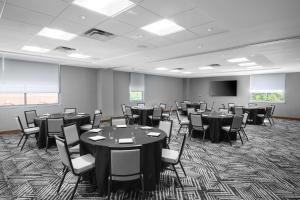 una sala de conferencias con mesas, sillas y una pantalla en Hyatt Place Albany en Albany