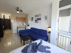 Il comprend un salon avec un canapé bleu et une cuisine. dans l'établissement Garajonay studio apartment in the center of Torremolinos, à Torremolinos