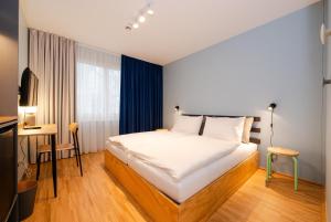 um quarto com uma cama, uma secretária e uma televisão em HausPension em Viena