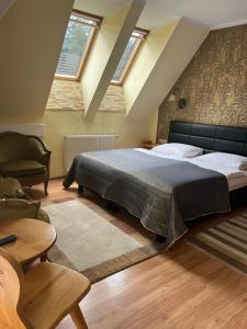 um quarto com uma cama grande e uma cadeira em Residenz Polenia em Zakopane