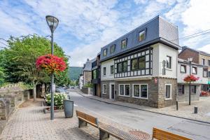 een gebouw op een straat met een bank en een straatlicht bij Li Rotche in La-Roche-en-Ardenne