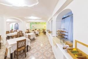 een restaurant met tafels en stoelen en een schilderij aan de muur bij Hotel Terme Principe in Ischia