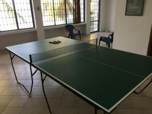 a ping pong table in a room with chairs at Casa Miramar in Santa Marta