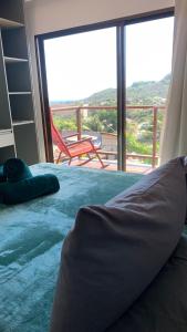 a bedroom with a bed with a view of a balcony at Flats Baia dos Porcos in Fernando de Noronha