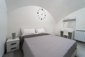 a bedroom with a bed and a clock on the wall at Camera con Vista in Naples