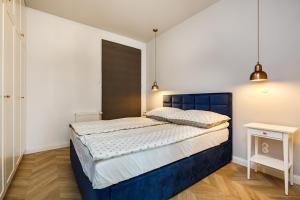 een slaapkamer met een blauw bed in een kamer bij Apart ,,Centrum Stare Miasto ,, Widok na Motławę in Gdańsk