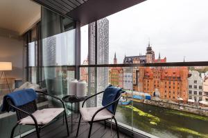 een balkon met een tafel en stoelen en uitzicht op de stad bij Apart ,,Centrum Stare Miasto ,, Widok na Motławę in Gdańsk