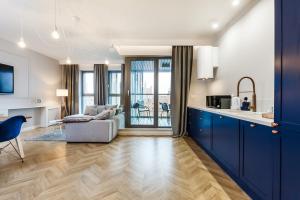 uma cozinha com armários azuis e uma sala de estar em Apart ,,Centrum Stare Miasto ,, Widok na Motławę em Gdańsk