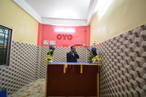 a man standing at a counter in a room at OYO Flagship Hotel Gloria Inn in Agartala