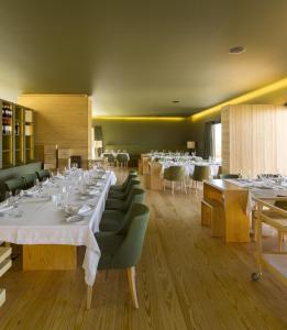 uma sala de jantar com mesas brancas e cadeiras verdes em Monverde - Wine Experience Hotel - by Unlock Hotels em Amarante