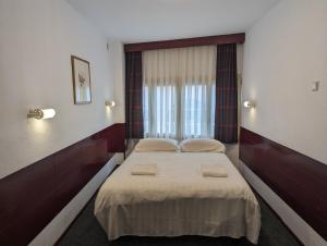 a bedroom with a bed with two pillows on it at Budget Hotel Ben in Amsterdam