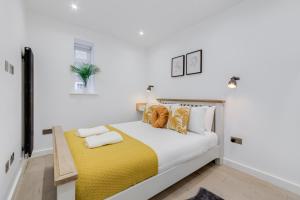 a bedroom with a bed with a yellow blanket at Deluxe 1 Bed Flat - Shoreditch, Aldgate & The City of London in London