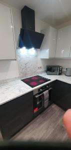 a kitchen with white cabinets and a stove top oven at Imperial Apartments. Brand New, 2 Bed In Goole. in Goole