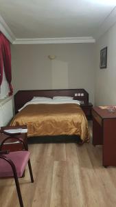 a bedroom with a bed and a dresser and a table at snowrose hotel in Şahinbey