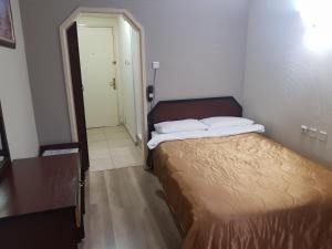 a small bedroom with a bed and a hallway at snowrose hotel in Şahinbey