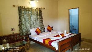 a bedroom with a bed and a window at Sundarban Tiger Roar Resort in Purbbadulki