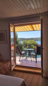 a bedroom with a door open to a balcony with a table at Apartment Maja in Mali Lošinj