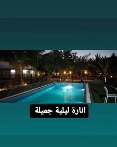 a picture of a swimming pool at night at The Holiday Farm in Barka