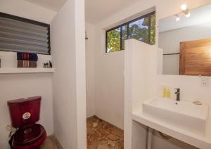 a bathroom with a toilet and a sink at TwoTen° Surf Home in Popoyo