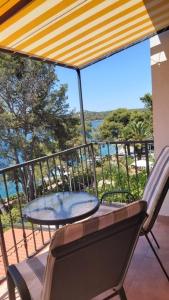 a table and chairs on a balcony with a view of the ocean at Apartment Maja in Mali Lošinj