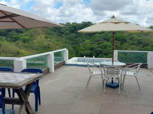 a patio with a table and chairs and an umbrella at Apartamentos Mobiliados in Aldeia