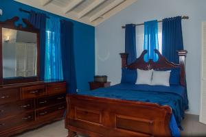 a bedroom with a bed and a dresser and a mirror at PARADISE VILLA ONSITE PRIVATE POOL ONSITE PRIVATE GYm 2 PROPERTIES SLEEP 12 TO BOOK FOR MORE THAN 6 PLEASE CONTACT US in Ocho Rios