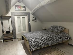a bedroom with a bed with a black and white comforter at L’escale féerique in Auxerre