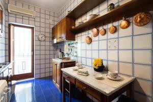 una cucina con pareti piastrellate in blu e bianco di Casa Nina a Sorrento