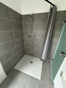 a bathroom with a shower with a tiled floor at Appartement Wolfshagen in Elbingerode