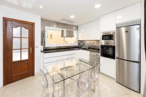 a kitchen with a glass table and a refrigerator at CASA SAN MATIAS in Granada