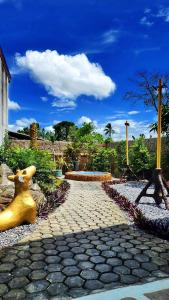 park z posągiem psa i ławką w obiekcie บ้านเพิงโฮมสเตย์ w mieście Ban Khuan Rai