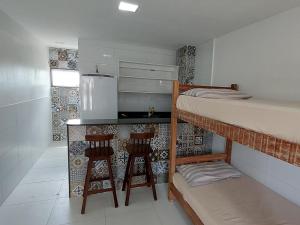 a small kitchen with a bunk bed and two bar stools at Apartamentos Mobiliados in Aldeia