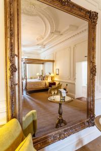 a large mirror in a room with a bedroom at Rushton Hall Hotel and Spa in Kettering