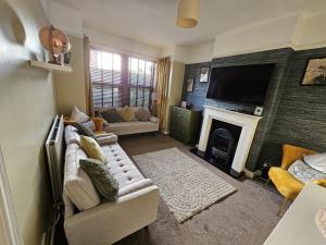 a living room with a couch and a fireplace at Spacious Home - King Size Bed - Pets - In Oak Hill in Trent Vale