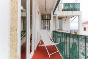 uma cadeira branca na varanda de um edifício em Estrela Panoramic Views by Homing em Lisboa